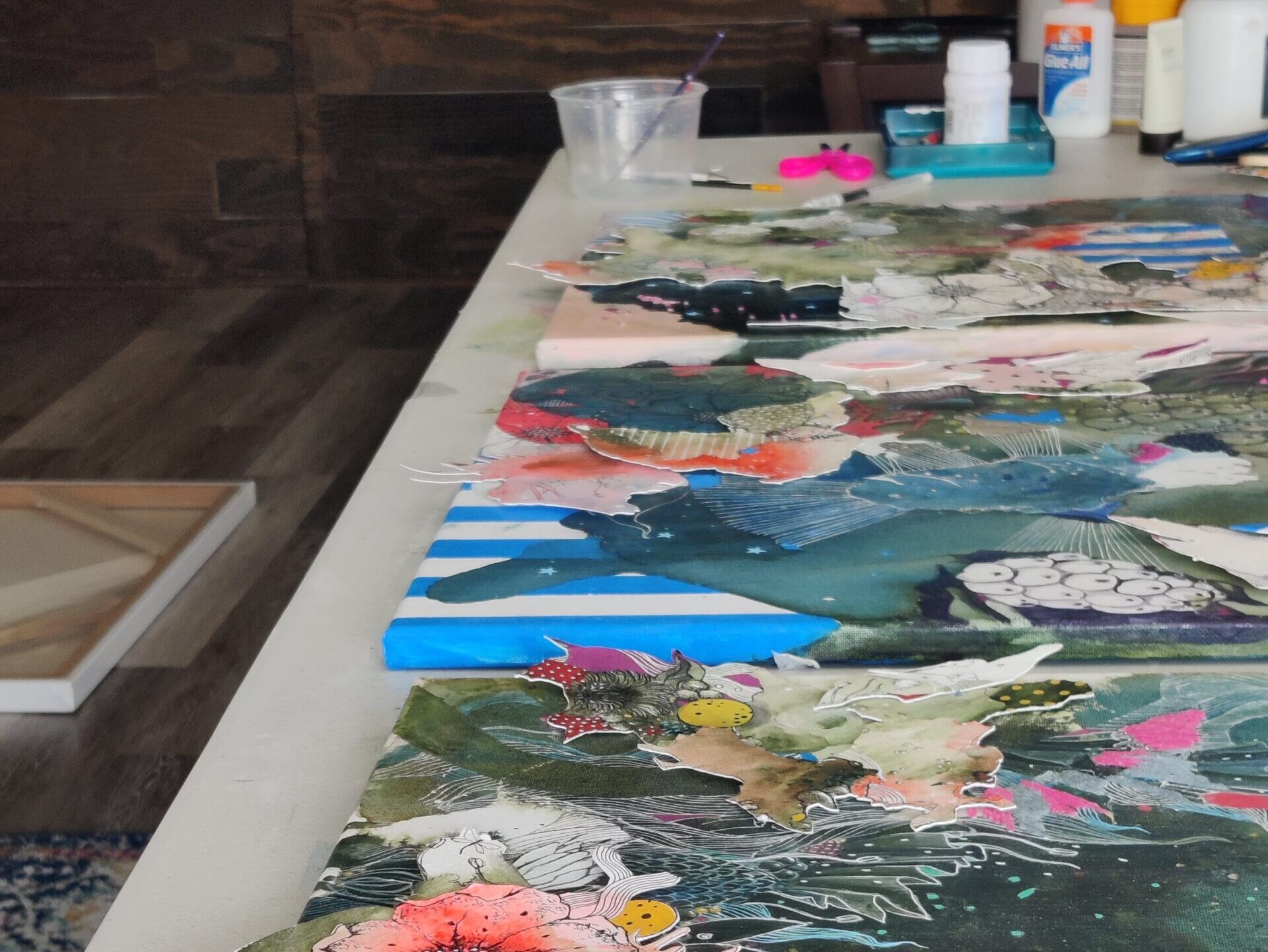 work in progress. the image shows mixed media paintings on the work desk in a studio
