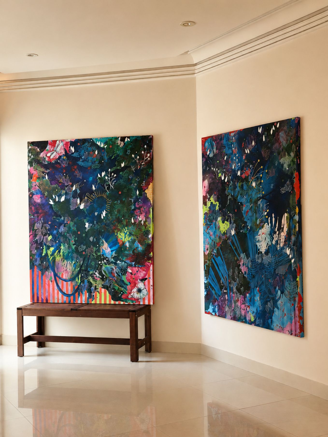 the image shows two abstract 48x60 in mixed painting by Asma Kazi that are insitu. One is rested on a becnh and the other is hung on a wall. Colour Paletter - Various shades of blue, pink and green Biomorphic elements - Florals, fungi like clusters, dragon flies, stars, faux cocoon